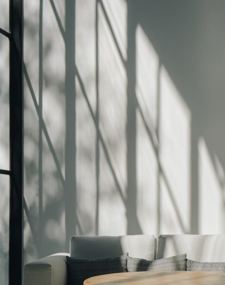Shadows On A Wall Above A White Couch