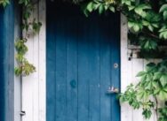 A Blue Door Surrounded By A Vine
